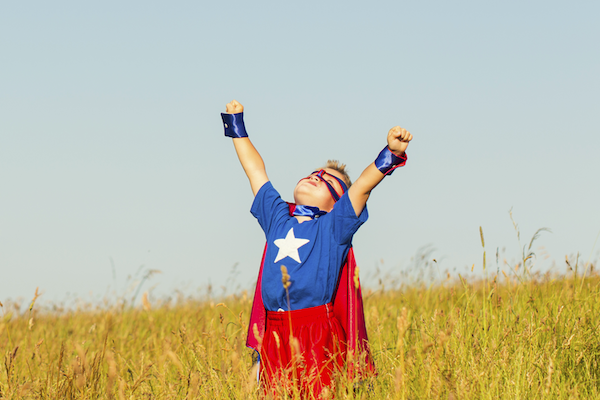 Superhero boy in victory pose representing successful payroll solution choice